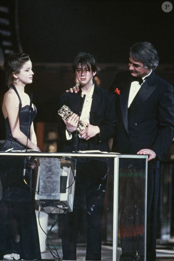 1986, Paris, France - L'actrice et chanteuse française Charlotte Gainsbourg avec Laure Marsac et Jean-Claude Brialy lors de la cérémonie des César, où elle a reçu le prix du meilleur espoir féminin pour son rôle dans le film L'Effronterie, réalisé par Claude Miller. Photo Pascal Baril/ABACAPRESS.COM