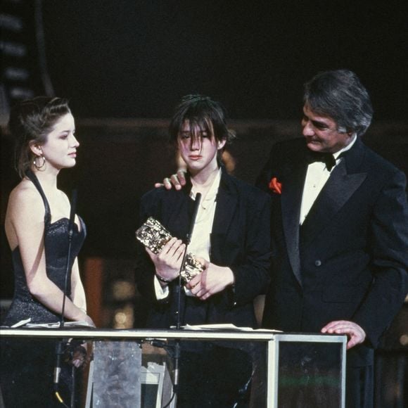 1986, Paris, France - L'actrice et chanteuse française Charlotte Gainsbourg avec Laure Marsac et Jean-Claude Brialy lors de la cérémonie des César, où elle a reçu le prix du meilleur espoir féminin pour son rôle dans le film L'Effronterie, réalisé par Claude Miller. Photo Pascal Baril/ABACAPRESS.COM