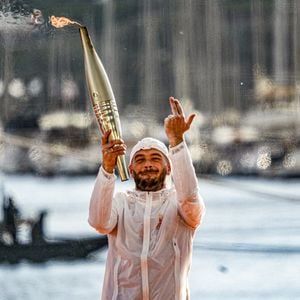 Le rappeur Jul embrase le chaudront olympique lors de la cérémonie d'arrivée de la flamme olympique au Vieux-Port de Marseille, France, le 8 mai 2024 @ Sandrine Thesillat/Panoramic/Bestimage