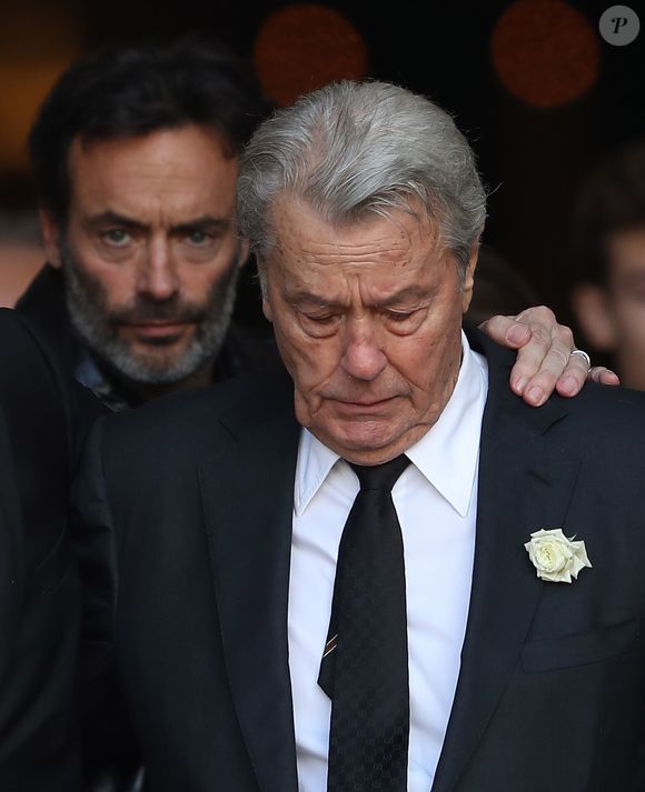 En effet lorsqu'il était jeune, Alain Delon a travaillé chez un commerçant boucher-charcutier à Bourg-la-Reine dans les Hauts-de-Seine avec son beau-père Paul Boulogne et avait même passé un certificat d'aptitude professionnelle de charcuterie. 

Alain Delon et son fils Anthony Delon - Sorties des obsèques de Mireille Darc en l’Église Saint-Sulpice à Paris. Le 1er septembre 2017. AGENCE / BESTIMAGE