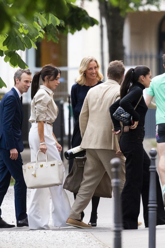 Exclusif - La famille Beckham (David Beckham, sa femme Victoria, Cruz Beckham, sa compagne Jackie Apostel, Roméo Beckham, sa compagne Kim Turnbull et Harper Seven) arrive à son hôtel fétiche "La Réserve" pour fêter les 50 ans de David Beckham (2 mai 1975) à Paris, France, le 2 mai 2025. David sort avec une bouteille de rouge pétrus Pomerol (surement l'année de sa naissance) à la main . © Bestimage