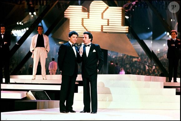Sacha Distel et Michel Drucker, lors de la soirée de privatisation de TF1, en 1987. BERTRAND RINDOFF PETROFF / BESTIMAGE