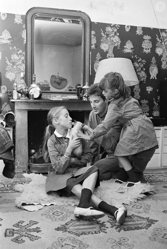 Archive - Hugues Aufray - En France, à Paris, Hugues AUFRAY chez lui, dans son appartement, assis par terre, accompagné par ses filles, Charlotte 5 ans et Marie 10 ans. Michel Ristroph via Bestimage