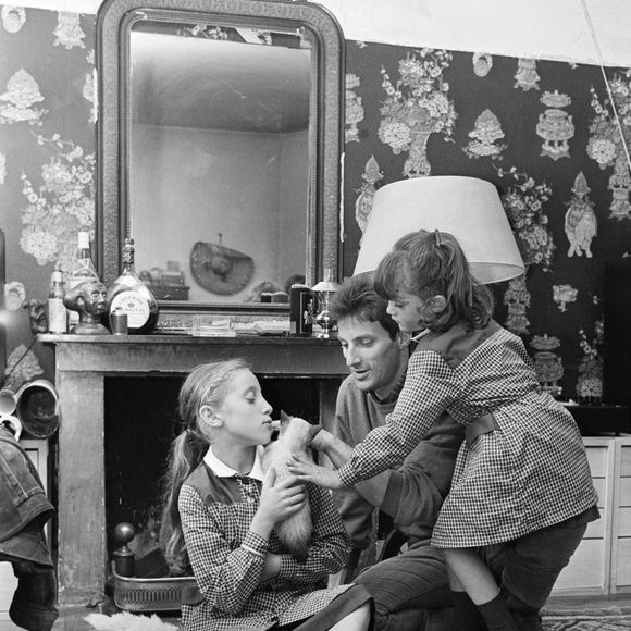 Archive - Hugues Aufray - En France, à Paris, Hugues AUFRAY chez lui, dans son appartement, assis par terre, accompagné par ses filles, Charlotte 5 ans et Marie 10 ans. Michel Ristroph via Bestimage