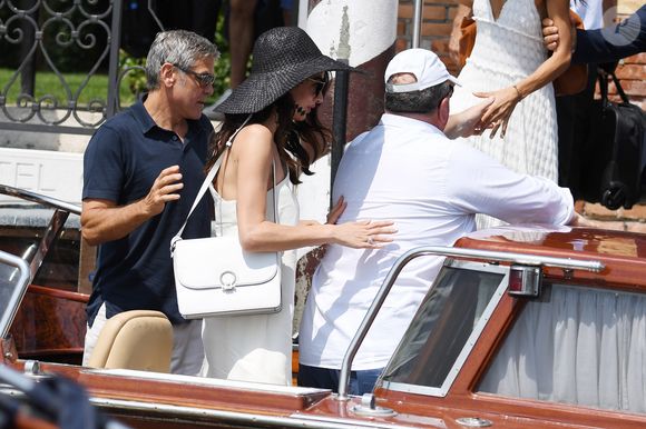 George Clooney et sa femme Amal Clooney sortent de leur hôtel, et prennent un bateau taxi pour se rendre dans un héliport pour s'envoler en hélicoptère de Venise, Italie, le 27 juin 2019.