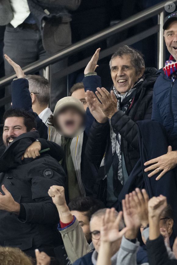 Julien Clerc et son fils Leonard - People dans les tribunes lors du match de ligue des champions entre le PSG et l'AC Milan au Parc des Princes à Paris le 25 octobre 2023. © Cyril Moreau/Bestimage
