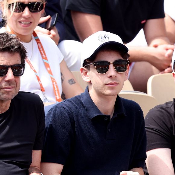 Patrick Bruel et ses fils Léon et Oscar dans les tribunes des Internationaux de France de tennis de Roland Garros 2024, le 4 juin 2024.