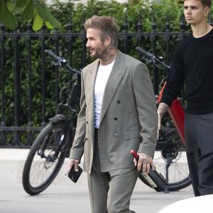 Exclusif - La famille Beckham (David Beckham, sa femme Victoria, Cruz Beckham, sa compagne Jackie Apostel, Roméo Beckham, sa compagne Kim Turnbull et Harper Seven) arrive à son hôtel fétiche "La Réserve" pour fêter les 50 ans de David Beckham (2 mai 1975) à Paris, France, le 2 mai 2025. David sort avec une bouteille de rouge pétrus Pomerol (surement l'année de sa naissance) à la main . © Bestimage