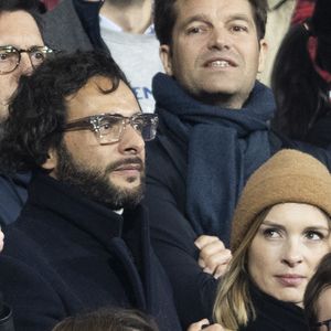 Maxim Nucci (Yodelice) et sa compagne Isabelle Ithurburu dans les tribunes lors du match de rugby du Tournoi des 6 Nations opposant la France à l'Angleterre au stade de France, à Saint-Denis, Seine Saint-Denis, France, le 19 mars 2022. © Cyril Moreau/Bestimage