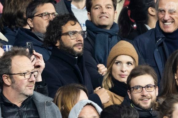 Maxim Nucci (Yodelice) et sa compagne Isabelle Ithurburu dans les tribunes lors du match de rugby du Tournoi des 6 Nations opposant la France à l'Angleterre au stade de France, à Saint-Denis, Seine Saint-Denis, France, le 19 mars 2022. © Cyril Moreau/Bestimage
