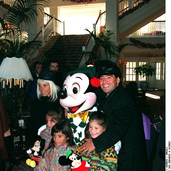 Diego Maradona - Marne-la-Vallée (France), 5 janvier 1995. Avec son épouse Claudia Villafañe et leurs filles Dalma et Giannina à Disneyland Paris, plan large, accroupis aux côtés de Mickey.
Crédit : Agence/Bestimage