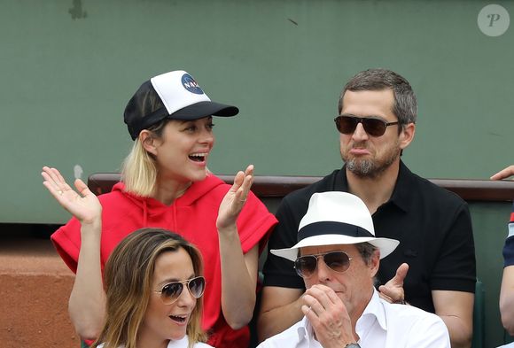 Marion Cotillard et son compagnon Guillaume Canet, Hugh Grant et sa femme Anna Eberstein dans les tribunes des Internationaux de France de Tennis de Roland Garros à Paris, le 10 juin 2018. © Jacovides/Moreau/Bestimage