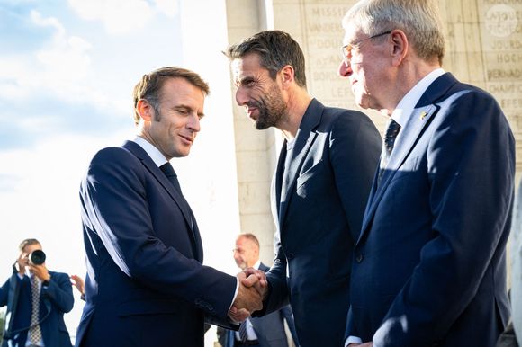 Le président français Emmanuel Macron, Tony Estanguet, président du COJO et Thomas Bach, président du CIO lors du ravivage de la flamme sur la tombe du Soldat inconnu à l'Arc de Triomphe lors du défilé des athlètes français ayant participé aux Jeux olympiques et paralympiques de Paris 2024 sur l'avenue des Champs-Elysées à Paris le 14 septembre 2024. Photo by Eric Tschaen/Pool/ABACAPRESS.COM