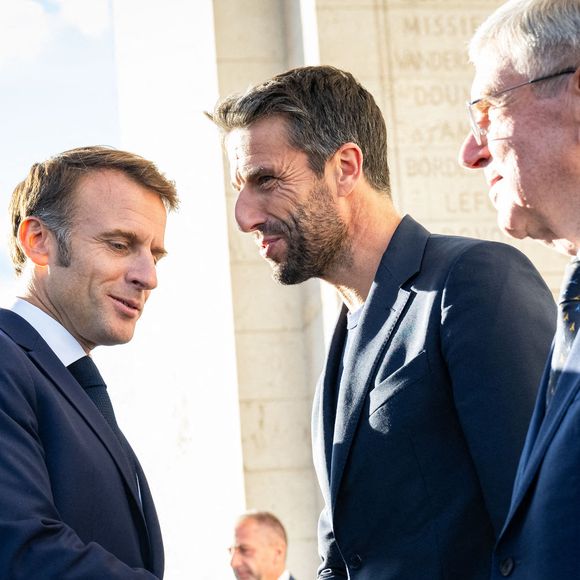 Le président français Emmanuel Macron, Tony Estanguet, président du COJO et Thomas Bach, président du CIO lors du ravivage de la flamme sur la tombe du Soldat inconnu à l'Arc de Triomphe lors du défilé des athlètes français ayant participé aux Jeux olympiques et paralympiques de Paris 2024 sur l'avenue des Champs-Elysées à Paris le 14 septembre 2024. Photo by Eric Tschaen/Pool/ABACAPRESS.COM