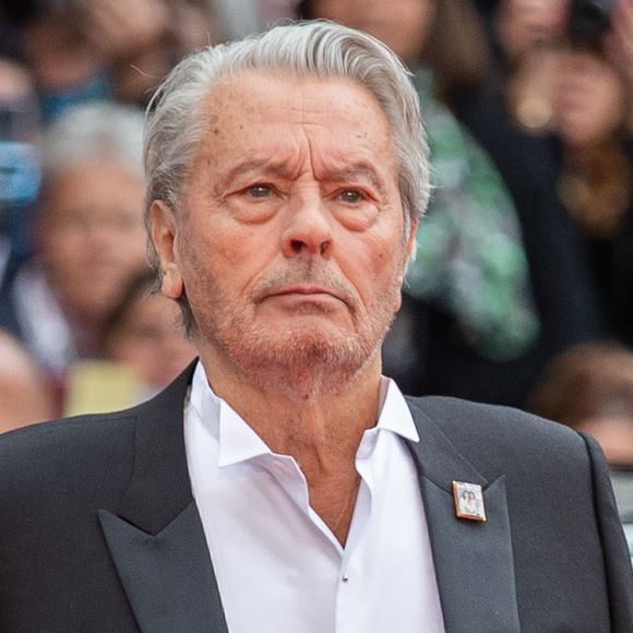Décédé d'une détresse respiratoire, l'origine de son décès de celui qui clamait être le fils illégitime d'Alain Delon n'a jamais été identifiée, ni même la date précise

Alain Delon (avec un badge Paris Match d'une ancienne couverture du magazine titrant "Alain Delon, mes deux amours, Rosalie et Anouchka) - Montée des marches du film "A Hidden Life" lors du 72ème Festival International du Film de Cannes. Le 19 mai 2019
© Borde / Bestimage
