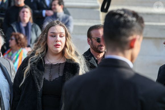 Le veuf Michel Ferracci, Milla Savarese, la fille de la défunte à la sortie des obsèques d'Emilie Dequenne au cimetière Père Lachaise à Paris, France, le 26 mars 2025. © Cyril Moreau/Bestimage