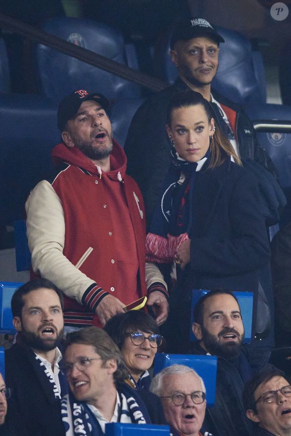 Michaël Youn et Constance Gay - Célébrités assistent au 1/8e de finale aller de la Ligue des champions 2024-25 entre le PSG contre Liverpool (0-1) au Parc des Princes à Paris le 5 mars 2025. © Cyril Moreau/Bestimage
