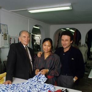 Archives - En France, à Paris, Pierre Cardin, Michel Drucker, et sa fille adoptive cambodgienne Yleng dans l'atelier de couture de chez Cardin où elle est première main. Septembre 1987
© Michel Ristroph via Bestimage
