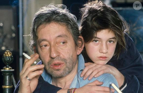 Archives  En France, à Paris, Serge Gainsbourg chez lui avec sa fille Charlotte dans son hotel particulier de la rue de Verneuil, posant au milieu de son bric-à-brac où il entasse des objets hétéroclites en mai 1985.  © Michel Marizy via Bestimage