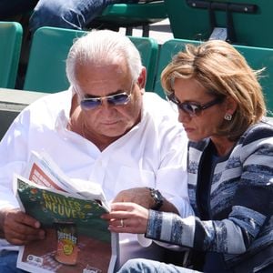 Dominique Strauss Kahn et Myriam L'Aouffir regardent un match lors du premier tour des Internationaux de France de tennis à Roland-Garros à Paris, France, le 30 mai 2015.