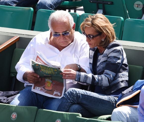 Dominique Strauss Kahn et Myriam L'Aouffir regardent un match lors du premier tour des Internationaux de France de tennis à Roland-Garros à Paris, France, le 30 mai 2015.