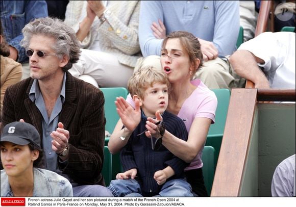 L'actrice française Julie Gayet, son mari Santiago Amigorena et son fils photographiés lors d'un match des Internationaux de France 2004 à Roland Garros à Paris-France le lundi 31 mai 2004. Photo Gorassini-Zabulon/ABACA.