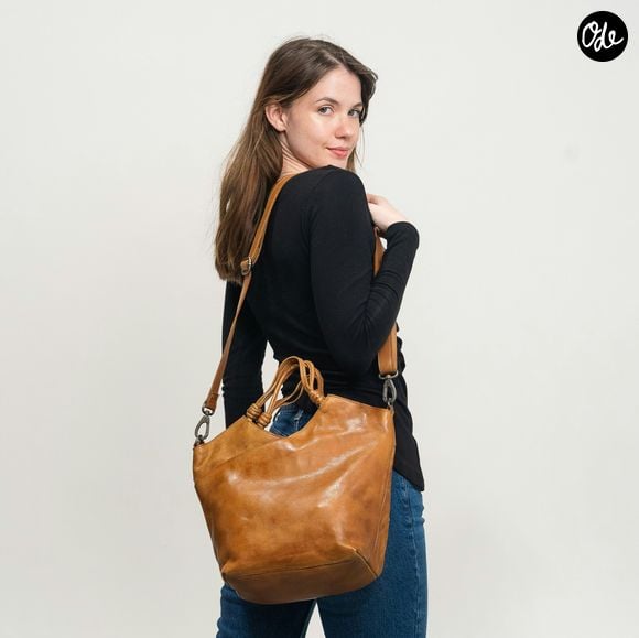 Ce modèle se définit comme un sac bandoulière semi-circulaire affichant une structure souple et plissée.