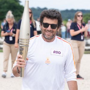 Le porteur de la flamme olympique Patrick Bruel lors du relais de la flamme des Jeux Olympiques de Paris le 23 juillet 2024 à Versailles, France. Photo par Laurent Zabulon/ABACAPRESS.COM