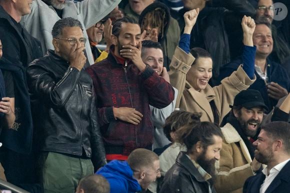 Roschdy Zem et son fils Chad Zem, Michou, , Adriana Lima et son compagnon Andre Lemmers, Benjamin Millepied et son fils Aleph - Célébrités des les tribunes lors du match aller du quart de finale de Ligue des champions entre le PSG et Aston Villa (3-1) au Parc des Princes à Paris le 9 avril 2025. © Cyril Moreau/Bestimage