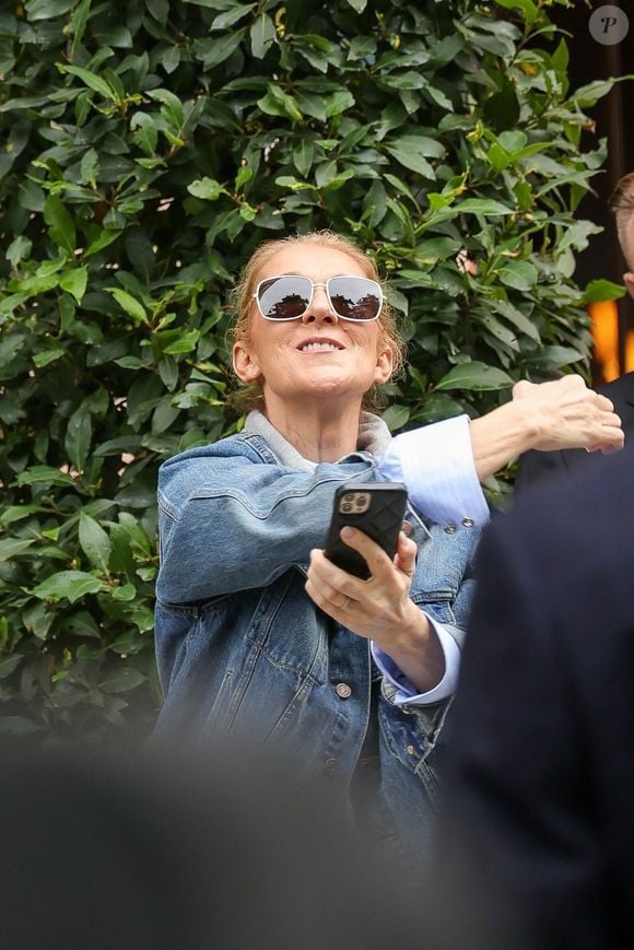 Paris, FRANCE - Celine Dion takes pictures and waves to fans as she prepares to perform for the Olympic Games in Paris, creating joyful memories with her admirers. Pictured: Céline Dion