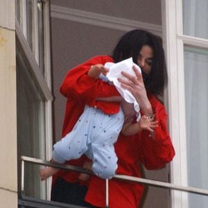 Michael Jackson, qui se trouve en Allemagne pour recevoir le Bambi d'or, prix récompensant l'ensemble de sa carrière, s'affiche à la fenêtre de sa luxueuse suite à l'hôtel Adlon, dans le centre de Berlin, en Allemagne, le 19 novembre 2002. Photo par Peter Bischoff/ABACAPRESS.COM