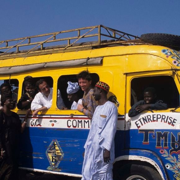 Un pays dont il est tombé amoureux 

Archive - Richard Bohringer. Au Sénégal, à Gorée, l'équipe de l'émission LA GRANDE VIE et du film LES CAPRICES DU FLEUVE, sur une falaise au bord de la mer, Bernard GIRAUDEAU, Richard BOHRINGER et DIAGNE le régisseur à la fenêtre d'un car aux couleurs vives de la ville de DAKAR