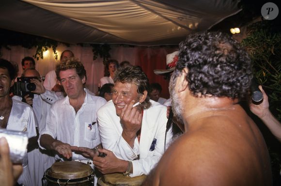 Archives -  En France, à Saint-Tropez, à l'occasion du premier anniversaire de mariage d'Eddie BARCLAY et Caroline BARCLAY, dans leur villa, Eddy Mitchell, Johnny HALLYDAY et Carlos. Juillet 1989
© Bruno Schneider via Bestimage
