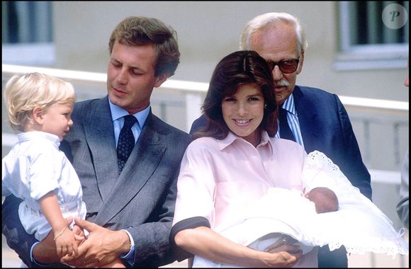 Née en août 1986 des amours de Caroline avec Stefano Casiraghi...

Caroline de Monaco à la sortie de la clinique avec sa fille Charlotte Casiraghi, accompagnées d’Andrea Casiraghi, de Stefano Casiraghi et du prince Rainier III, à Monaco, le 6 août 1986.
Crédit : Daniel Angeli/Bestimage