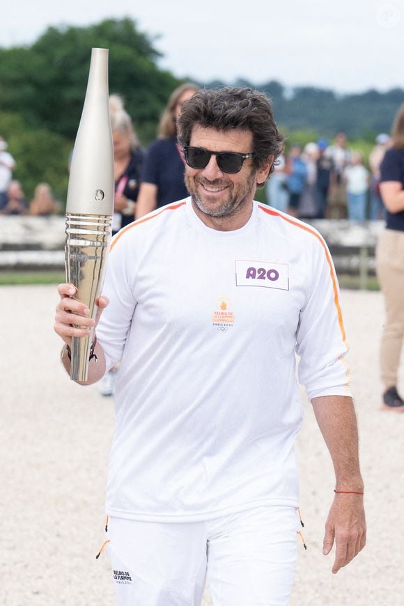 Le porteur de la flamme olympique Patrick Bruel lors du relais de la flamme des Jeux Olympiques de Paris le 23 juillet 2024 à Versailles, France. Photo par Laurent Zabulon/ABACAPRESS.COM