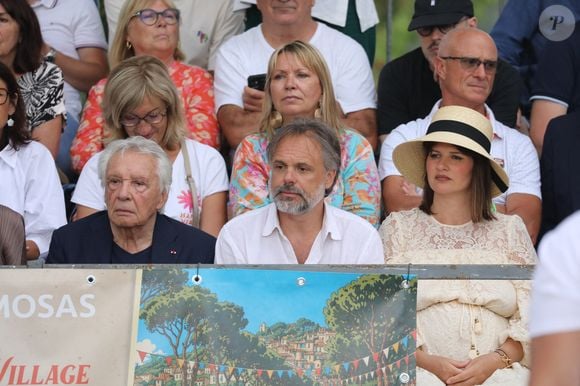 "Mon grand-père est resté dans la mémoire d’une génération, mais c’est important de la faire perdurer. J’espère que ce trophée à son nom durera dans le temps. Ce serait lui rendre un joli hommage", a confié Romain, le fils de Michel Sardou.

Michel Sardou, Romain Sardou et sa compagne Kym Thiriot enceinte - Michel Sardou rend hommage à son père en famille lors du premier trophée de pétanque "Fernand Sardou" à Bormes-les-Mimosas le 29 mai 2026. Le célèbre chanteur est venu en famille avec sa femme, son fils Romain avec son fils de deux ans et demi et de sa compagne enceinte de son deuxième enfant.

© Franz Chavaroche/Bestimage