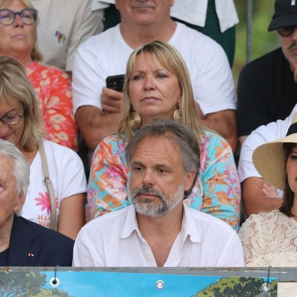 "Mon grand-père est resté dans la mémoire d’une génération, mais c’est important de la faire perdurer. J’espère que ce trophée à son nom durera dans le temps. Ce serait lui rendre un joli hommage", a confié Romain, le fils de Michel Sardou.

Michel Sardou, Romain Sardou et sa compagne Kym Thiriot enceinte - Michel Sardou rend hommage à son père en famille lors du premier trophée de pétanque "Fernand Sardou" à Bormes-les-Mimosas le 29 mai 2026. Le célèbre chanteur est venu en famille avec sa femme, son fils Romain avec son fils de deux ans et demi et de sa compagne enceinte de son deuxième enfant.

© Franz Chavaroche/Bestimage