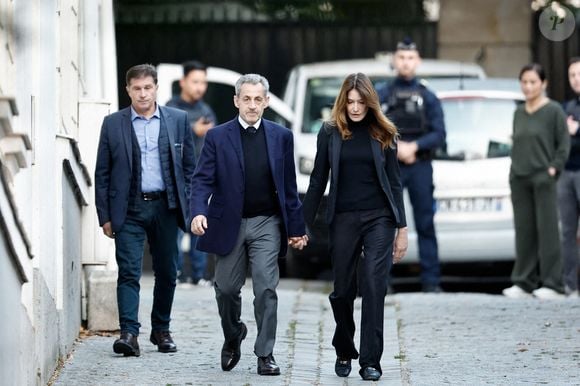 Nicolas Sarkozy, accompagné de sa femme Carla Bruni-Sarkozy, sort de son domicile pour être incarcéré à la prison de La Santé à Paris le 21 octobre 2025. © Moreau / Jacovides / Bestimage