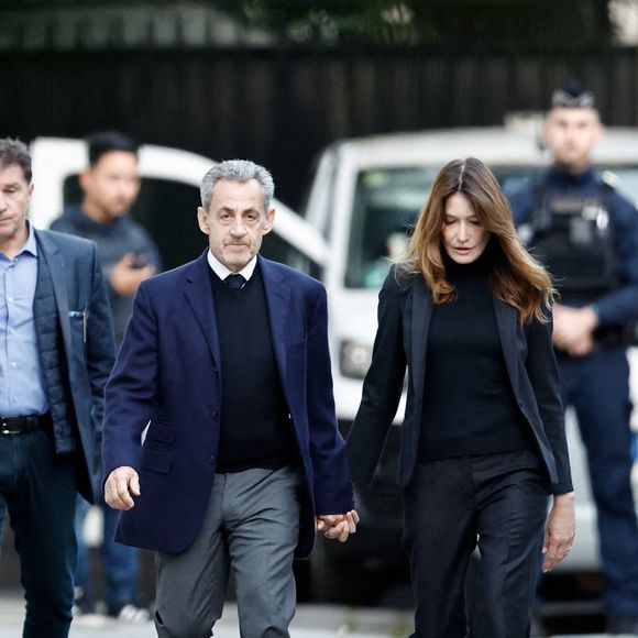 Nicolas Sarkozy, accompagné de sa femme Carla Bruni-Sarkozy, sort de son domicile pour être incarcéré à la prison de La Santé à Paris le 21 octobre 2025. © Moreau / Jacovides / Bestimage