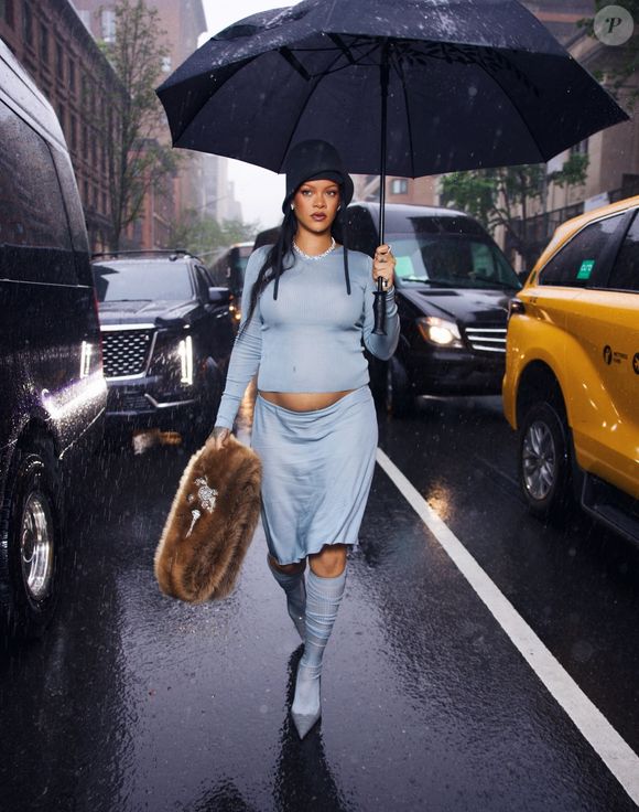 Rihanna sort sous la pluie, dévoilant fièrement son baby bump avant le Met Gala. Photo par Messika via Bestimage