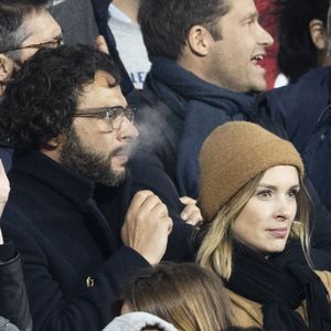 Maxim Nucci (Yodelice) et sa compagne Isabelle Ithurburu dans les tribunes lors du match de rugby du Tournoi des 6 Nations opposant la France à l'Angleterre au stade de France, à Saint-Denis, Seine Saint-Denis, France, le 19 mars 2022. © Cyril Moreau/Bestimage