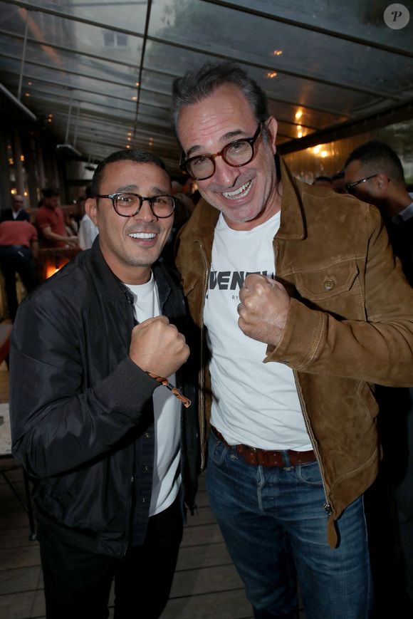 L’acteur était entouré de personnalités comme Philippe Caverivière, Brahim Asloum, Adil Rami, Bernard Le Coq ou encore Michel Crémadès.

Brahim Asloum et Jean Dujardin (tous en photos dans le livre) - Vernissage de l'exposition photos et du livre "La Boxe fait son cinéma" à l’hôtel Brach à Paris le 23 Septembre 2025. Ces clichés rendent hommage à plus de cinquante acteurs immortalisés dans des scènes où le noble art rencontre le 7ème art. © Bertrand Rindoff / Bestimage