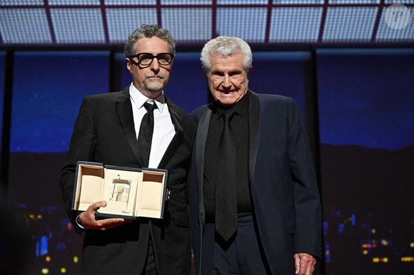 Le réalisateur brésilien Kleber Mendonca Filho reçoit le prix du meilleur réalisateur et est accompagné par le réalisateur français Claude Lelouch pour le film "O Agente Secreto" (L'agent secret) du réalisateur français Claude Lelouch lors de la cérémonie de clôture de la 78e édition du Festival de Cannes à Cannes, dans le sud de la France, le 24 mai 2025.