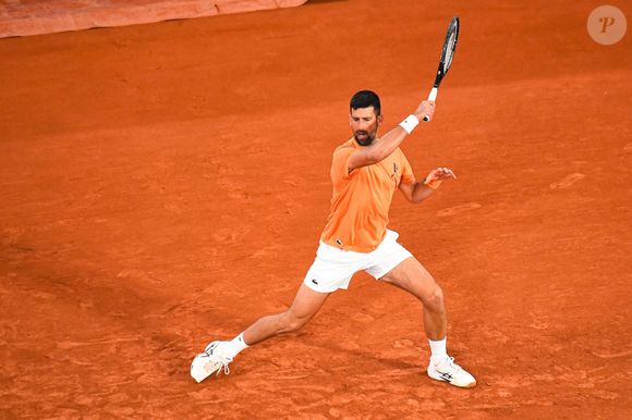 Le vêtement arbore une superbe couleur ocre, mais le secret va bien plus loin qu'une simple teinture. En effet, la veste a été travaillée en utilisant de la véritable terre battue pour créer sa texture et ses nuances si particulières.

Novak Djokovic (SRB) aux internationaux de France de Tennis de Roland Garros 2026, à Paris, France, le 19 mai 2026. © Baptiste Autissier/Psnewz/Bestimage