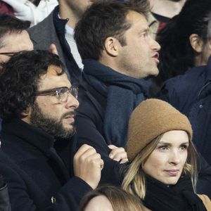 Maxim Nucci (Yodelice) et sa compagne Isabelle Ithurburu dans les tribunes lors du match de rugby du Tournoi des 6 Nations opposant la France à l'Angleterre au stade de France, à Saint-Denis, Seine Saint-Denis, France, le 19 mars 2022. © Cyril Moreau/Bestimage