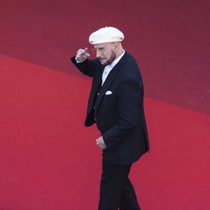 Loin d'être un simple hommage cliché à la culture française, ce choix fashion a une signification touchante. 

John Travolta - Montée des marches du film " Karma " lors du 79ème Festival International du Film de Cannes, le 15 mai 2026. © Camilla Canalini / Bestimage