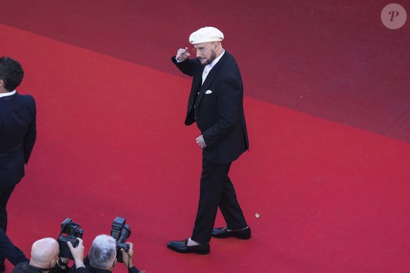 Loin d'être un simple hommage cliché à la culture française, ce choix fashion a une signification touchante. 

John Travolta - Montée des marches du film " Karma " lors du 79ème Festival International du Film de Cannes, le 15 mai 2026. © Camilla Canalini / Bestimage
