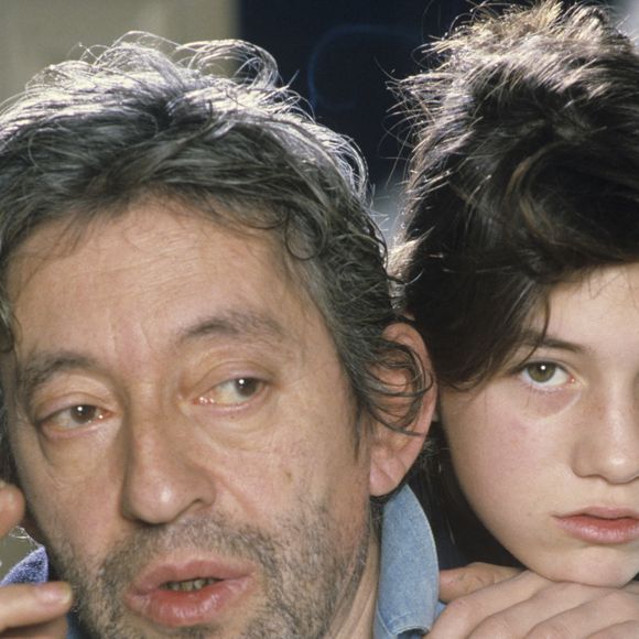 En France, à Paris, en mai 1985, Serge Gainsbourg chez lui avec sa fille Charlotte dans son hôtel particulier de la rue de Verneuil, posant au milieu de son bric-à-brac où il entasse des objets hétéroclites (Archives). © Michel Marizy via Bestimage