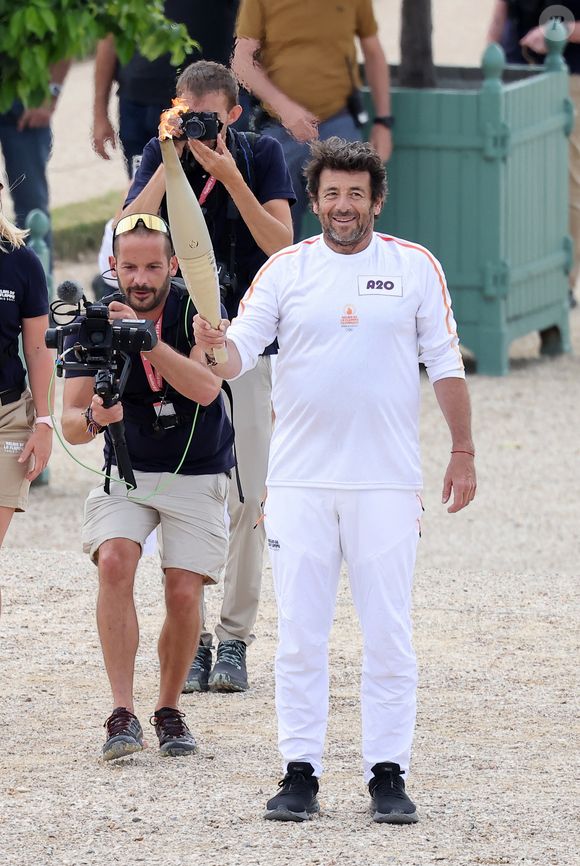 Le chanteur et acteur Patrick Bruel porteur de la flamme olympique des Jeux Olympiques de Paris 2024 (JO) au château de Versailles dans les Yvelines, France, le 23 juillet 2024. © Dominique Jacovides/Bestimage
