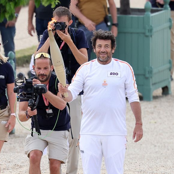 Le chanteur et acteur Patrick Bruel porteur de la flamme olympique des Jeux Olympiques de Paris 2024 (JO) au château de Versailles dans les Yvelines, France, le 23 juillet 2024. © Dominique Jacovides/Bestimage